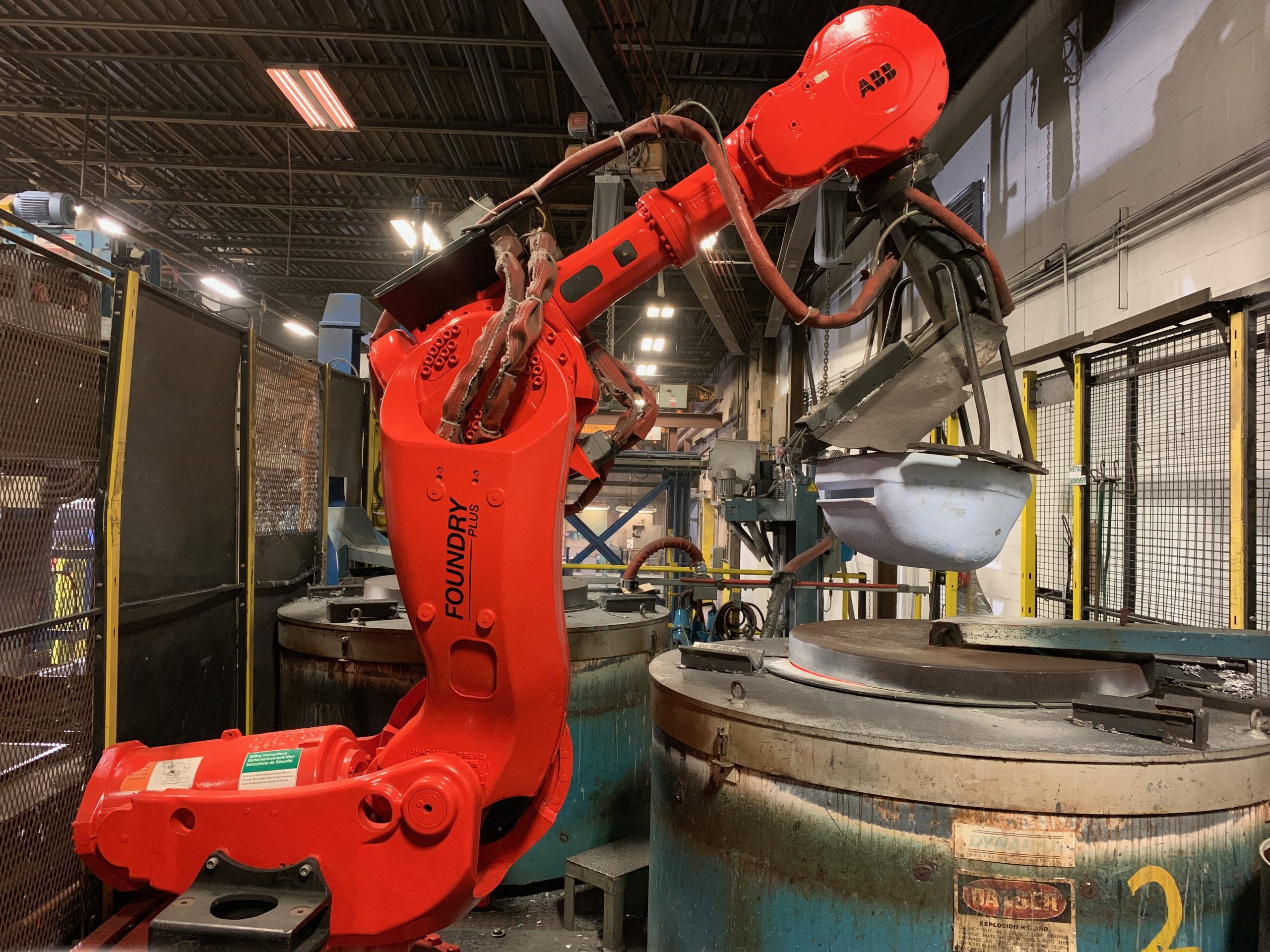 A robotic arm in the aluminum foundry, preparing to pour molten metal.
