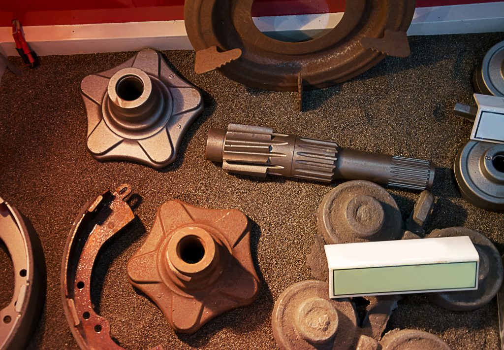A set of vehicle parts arranged in a sand bed