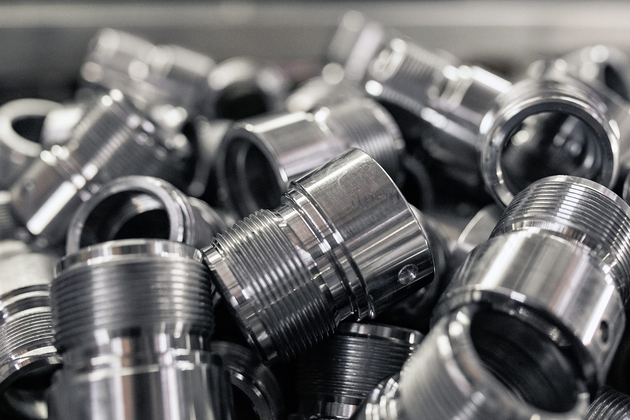 A pile of metal tubes with threading.