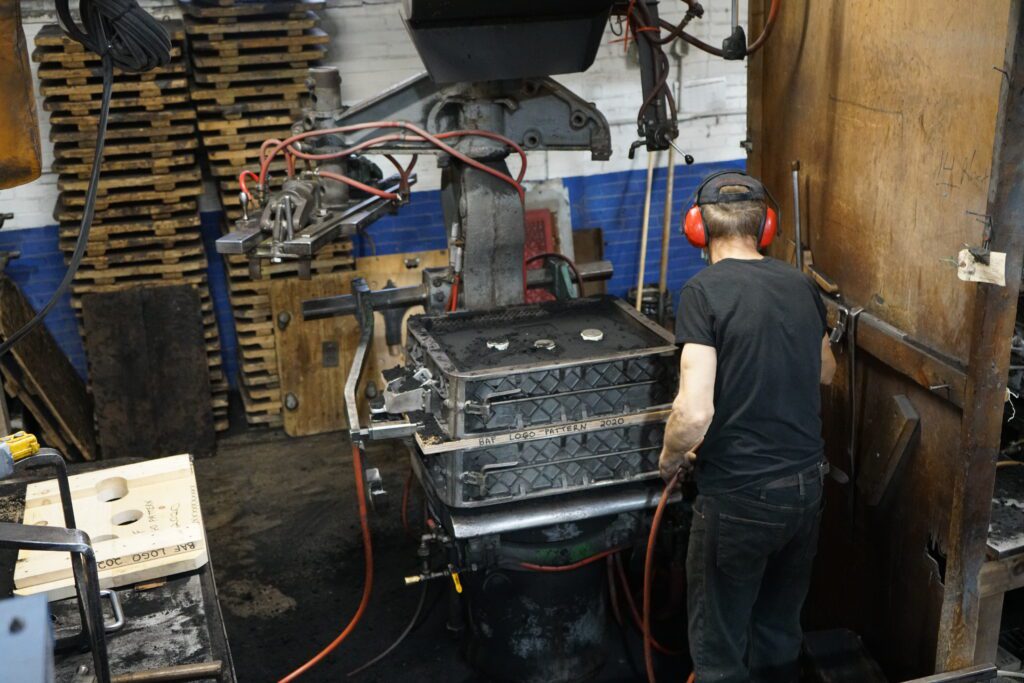 A person wearing ear protection works in the workshop on a project.